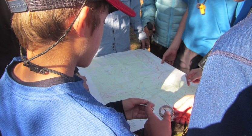 an outward bound student uses a map and compass